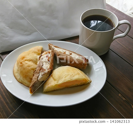 早餐桌上擺放著麵包和咖啡，這是一個令人愉悅的早晨景象。 141062313