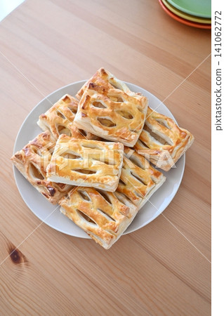 A freshly baked dessert consisting of stacked homemade mini apple pies. A freshly baked dessert consisting of stacked homemade mini apple pies. 141062772