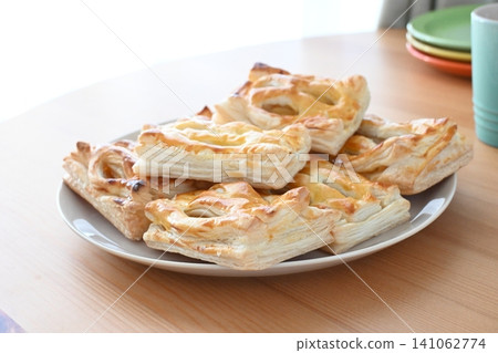 A freshly baked dessert consisting of stacked homemade mini apple pies. A freshly baked dessert consisting of stacked homemade mini apple pies. 141062774