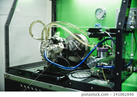 Diesel common rail high pressure fuel pump installed on automated test bench for flow rate calibration in workshop Diesel common rail high pressure fuel pump installed on automated test bench for flow rate calibration in workshop 141062840