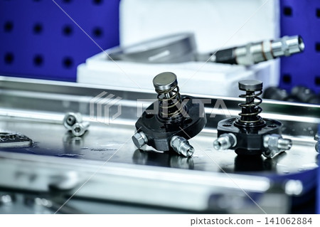 Disassembled fuel pump plungers and springs components on metal tray during high pressure diesel injection system repair Disassembled fuel pump plungers and springs components on metal tray during high pressure diesel injection system repair 141062884