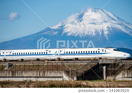 東海道山陽線列車飛馳而過，富士山巍峨聳立在背景中。 141063029
