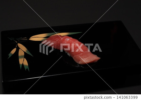 High-quality medium fatty tuna nigiri sushi that stands out against a black background. Served in a black lacquered dish, creating a traditional Japanese cuisine image. High-quality medium fatty tuna nigiri sushi that stands out against a black background. Served in a black lacquered dish, creating a traditional Japanese cuisine image. 141063399