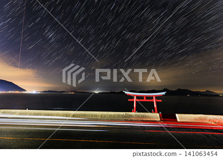 Autumn starry landscape of the Seto Inland Sea: Star trails and car tracks Autumn starry landscape of the Seto Inland Sea: Star trails and car tracks 141063454