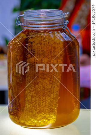Honey with honeycomb in jar Honey with honeycomb in jar 141063574