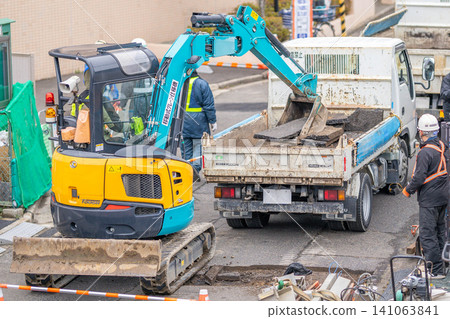 Seismic reinforcement work on combined sewer pipes (rehabilitation method), removal of asphalt pavement, road excavation, workers. 141063841