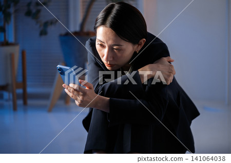 A woman watching a smartphone A woman watching a smartphone 141064038