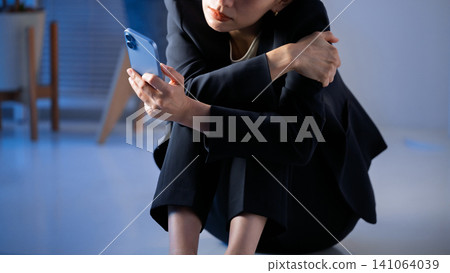 A woman watching a smartphone A woman watching a smartphone 141064039