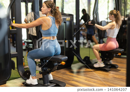 Woman doing exercises for back and shoulder muscles in the gym 141064207