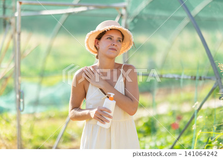 Female rural worker uses sunscreen Female rural worker uses sunscreen 141064242