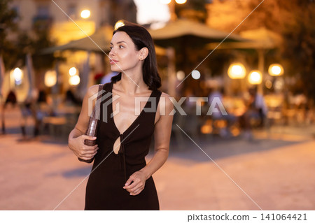 In evening, smiling girl walks around old city district Barceloneta, in vicinage of Passeig Nou In evening, smiling girl walks around old city district Barceloneta, in vicinage of Passeig Nou 141064421