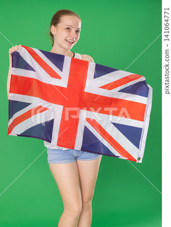 Teenage girl holding UK flag in front of green screen Teenage girl holding UK flag in front of green screen 141064771