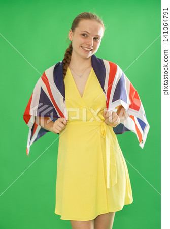 Teenage girl holding UK flag in front of green screen 141064791