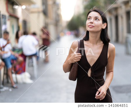 Young woman walks along narrow street in old Barcelona Young woman walks along narrow street in old Barcelona 141064851