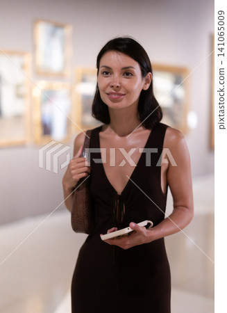 Woman visiting museum and looking at paintings Woman visiting museum and looking at paintings 141065009