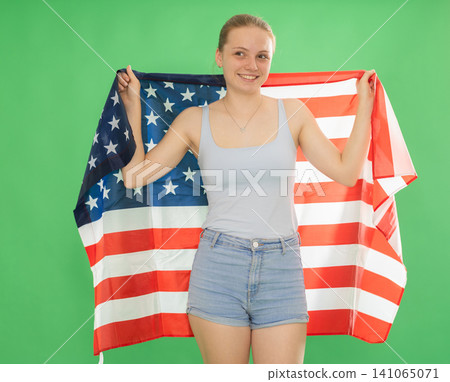 Teenage girl holding USA flag in front of green screen Teenage girl holding USA flag in front of green screen 141065071