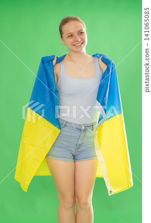 woman in casual clothes holding Ukraine flag on chromakey 141065085