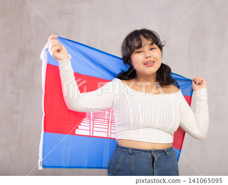 Smiling young girl holding Cambodia flag Smiling young girl holding Cambodia flag 141065095