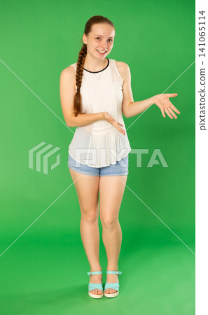 Teenage girl explaining or telling something in front of green screen Teenage girl explaining or telling something in front of green screen 141065114
