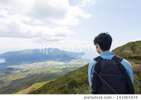 The back view of a student climbing Mount Hachijo-Fuji The back view of a student climbing Mount Hachijo-Fuji 141065834