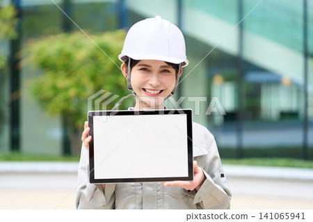 Construction workers using tablets to manage the project schedule Construction workers using tablets to manage the project schedule 141065941