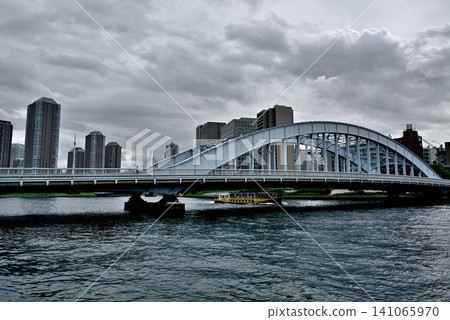 A view of the tower apartment buildings in Tsukuda, Chuo Ward, across the Eitai Bridge from the Sumida River Terrace, accompanied by rain clouds. A view of the tower apartment buildings in Tsukuda, Chuo Ward, across the Eitai Bridge from the Sumida River Terrace, accompanied by rain clouds. 141065970