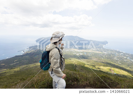 一位女子正在八丈富士山的健行步道上行走 一位女子正在八丈富士山的健行步道上行走 141066021
