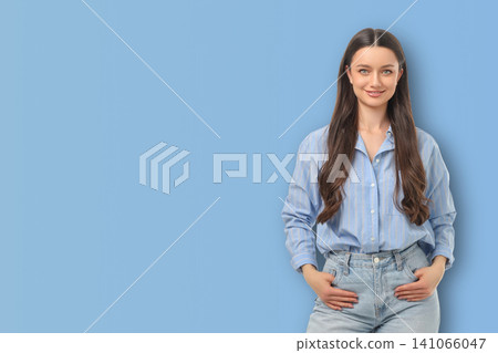 Model stands in blue space with hands in pockets Model stands in blue space with hands in pockets 141066047