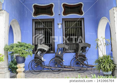Colorful house with blue walls and black window bars Colorful house with blue walls and black window bars 141066764