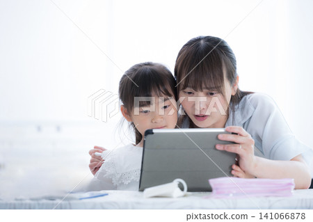 一位家長和孩子正在用平板電腦查找有關網路問題的資訊;一位母親和一位小學生正在學習資訊倫理。 一位家長和孩子正在用平板電腦查找有關網路問題的資訊;一位母親和一位小學生正在學習資訊倫理。 141066878
