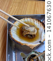 Close-up of grilled shellfish served on a metal tray (food stall, market, food ingredients) 141067630