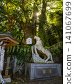 陽光透過樹葉灑在神聖的馬匹雕像和神聖的樹上。 141067699