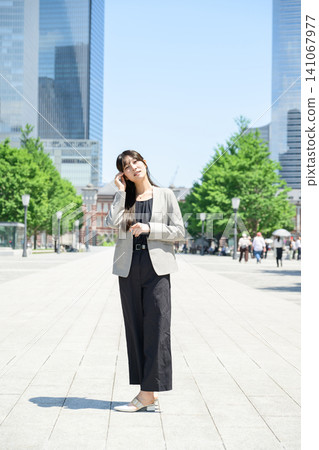 Japanese woman standing in a city of skyscrapers Japanese woman standing in a city of skyscrapers 141067977