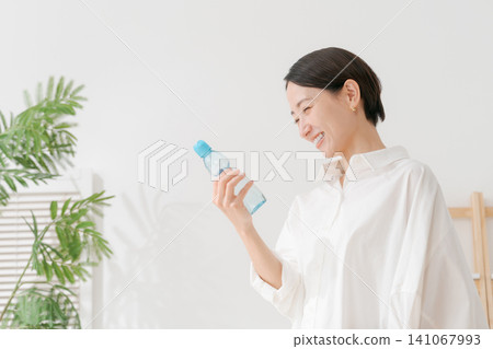 一位女士正在喝冰檸檬水。 一位女士正在喝冰檸檬水。 141067993
