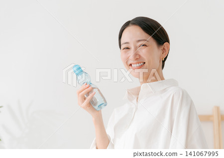 A woman drinking cold lemonade. 141067995