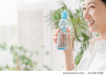 A woman drinking cold lemonade. A woman drinking cold lemonade. 141067996