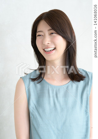 A Japanese woman smiling in a brightly lit room A Japanese woman smiling in a brightly lit room 141068016