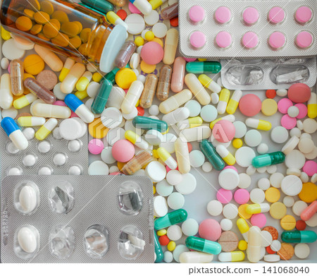 High angle full frame texture of medical pills, tablets, and capsules spilled with dark bottle High angle full frame texture of medical pills, tablets, and capsules spilled with dark bottle 141068040