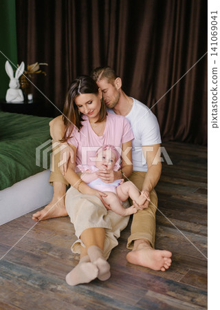 Loving Parents Holding Baby Girl At Home Loving Parents Holding Baby Girl At Home 141069041