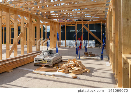 Interior of Timber Frame House Under Construction with Exposed Wooden Structure and Building Materials Interior of Timber Frame House Under Construction with Exposed Wooden Structure and Building Materials 141069070