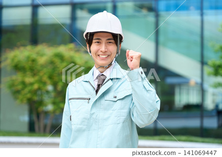 Asian man standing in work clothes Asian man standing in work clothes 141069447