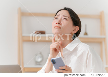 一個看到智能手機時沮喪的女人 一個看到智能手機時沮喪的女人 141069553