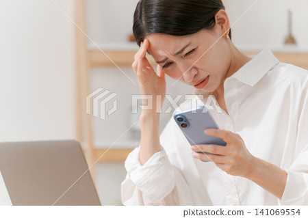 A woman who is depressed when she sees a smartphone 141069554