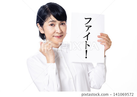 一名身穿白襯衫的中年男子舉著一塊寫著「戰鬥」的牌子，擺出勝利的姿勢。 141069572