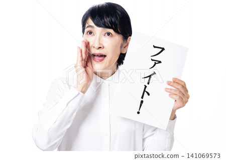 一位身穿白襯衫的中年婦女舉著一塊寫著「戰鬥」的牌子，為跑者加油。 141069573