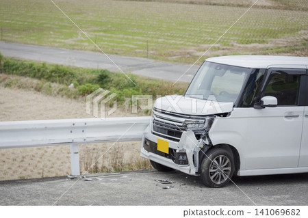Close-up of a white minicar that was damaged after colliding with a guardrail. Close-up of a white minicar that was damaged after colliding with a guardrail. 141069682