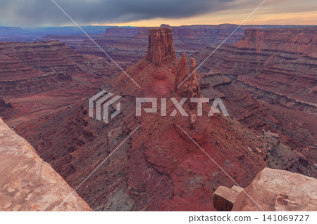 Majestic red rock canyon landscape in utah offering an awe inspiring and peaceful view over vast desert valley beneath dramatic sky during beautiful sunset 141069727