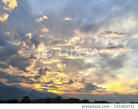 金色的夕陽和南阿爾卑斯山脈;背景圖片為夕陽西下,雲海翻騰。 金色的夕陽和南阿爾卑斯山脈;背景圖片為夕陽西下,雲海翻騰。 141069732