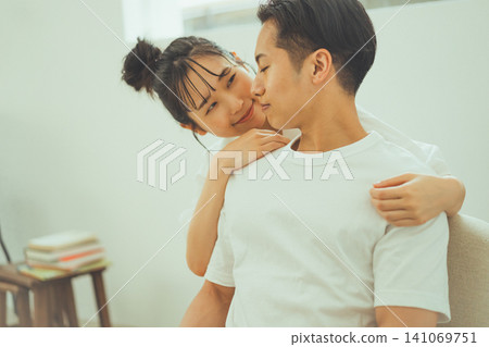 A loving couple: A woman smiles and clings to the man's neck. A loving couple: A woman smiles and clings to the man's neck. 141069751