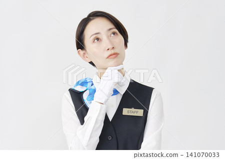Female staff member, receptionist/bus guide, thinking, white background. Female staff member, receptionist/bus guide, thinking, white background. 141070033